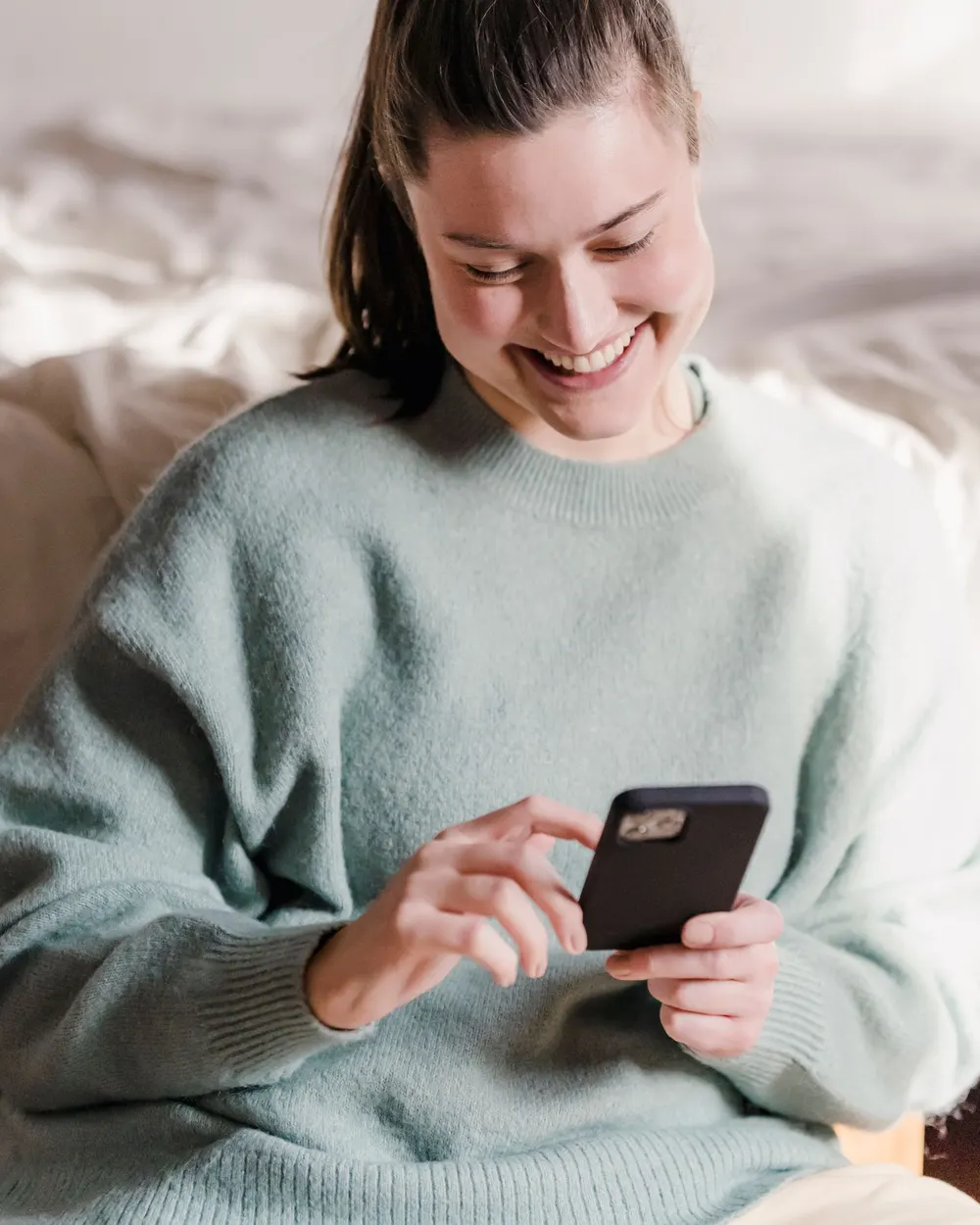 Woman smiling at her phone